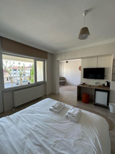 a bedroom with a large white bed and a large window at Well Hotel Edirne in Edirne