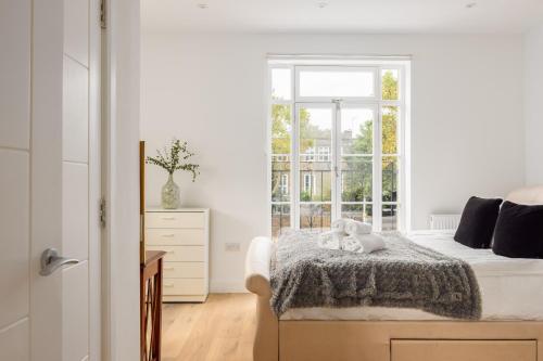 a bedroom with a bed with two teddy bears on it at Kensington High Street Apartments in London