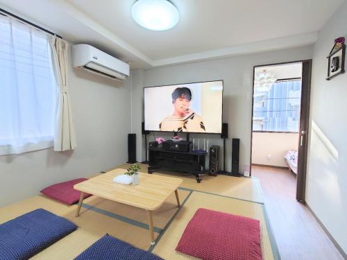 a living room with a flat screen tv on the wall at kaneshiro guest house in Tokyo