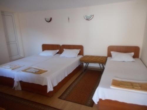 2 Einzelbetten in einem Zimmer mit 2 Tischen in der Unterkunft Guest House Borisov in Shabla