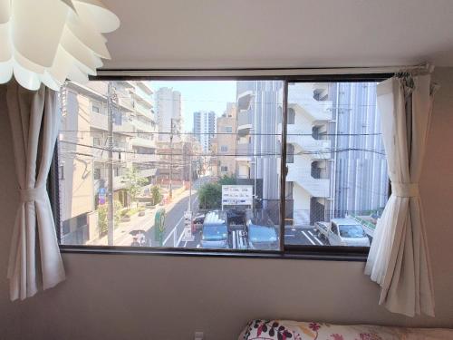 a window with a view of a city street at kaneshiro guest house in Tokyo