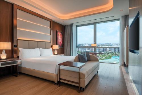 a bedroom with a bed and a couch and a large window at Hilton Tashkent City in Tashkent