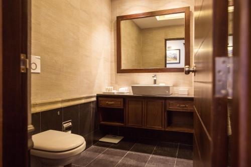 a bathroom with a toilet and a sink and a mirror at Chandragiri Hills Resort Kathmandu-Luxury in the Clouds in Thānkot