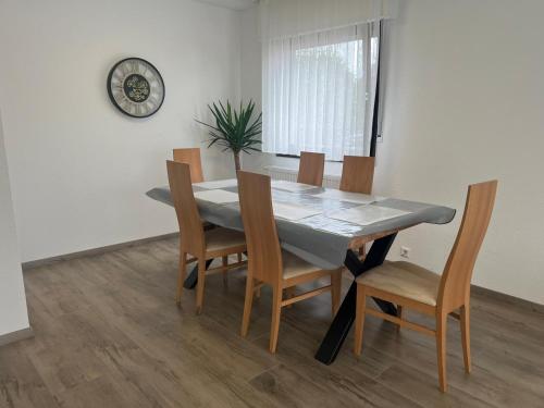 tavolo da pranzo con sedie e orologio sul muro di Timeless: Schönes 4 Zimmer Apartment EG a Trossingen