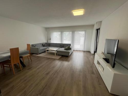 uma sala de estar com um sofá e uma televisão em Timeless: Schönes 4 Zimmer Apartment EG em Trossingen