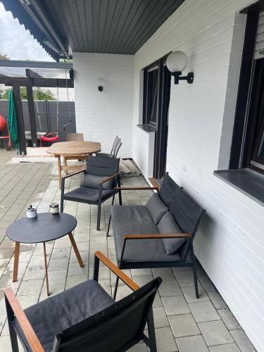 um pátio com cadeiras, mesas e uma mesa em Timeless: Schönes 4 Zimmer Apartment EG em Trossingen