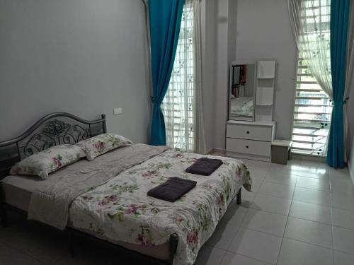 a bedroom with a bed with two pillows on it at Amara Homestay Kuantan in Kampong Bugis