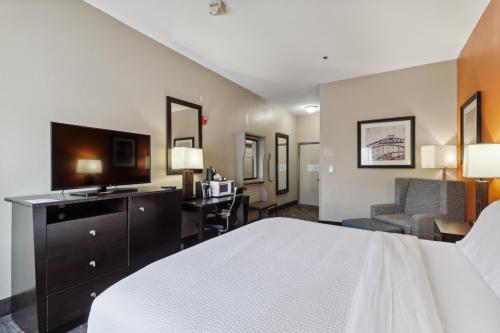 a hotel room with a bed and a desk and chair at Holiday Inn Hotel & Suites Slidell by IHG in Slidell