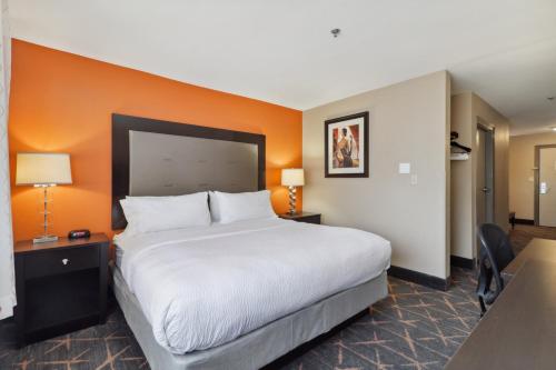 a bedroom with a large bed and an orange wall at Holiday Inn Hotel & Suites Slidell by IHG in Slidell
