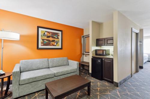 a living room with a couch and a kitchen at Holiday Inn Hotel & Suites Slidell by IHG in Slidell