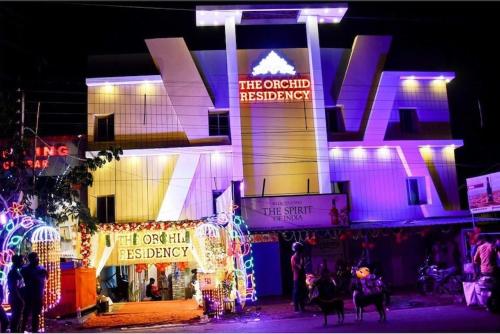 um edifício com luzes de Natal e pessoas à frente dele em Super OYO The Orchid Residency em Calcutá