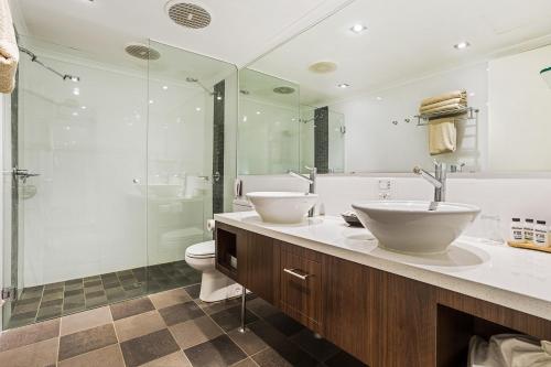 a bathroom with a sink and a toilet and a shower at Karratha International Hotel in Karratha