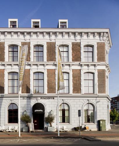 a white building with flags in front of it at Suitehotel Pincoffs in Rotterdam