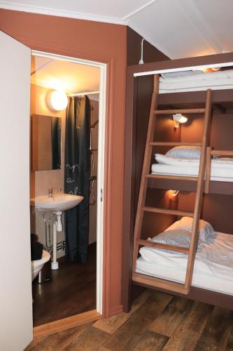 a bunk bed in a room with a sink and a mirror at Borås Camping & Vandrahem in Borås