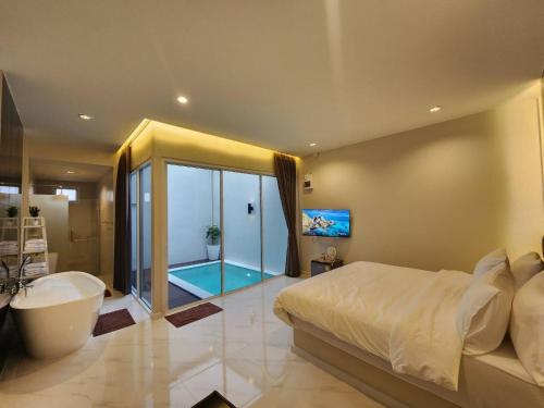 ein Schlafzimmer mit einer Badewanne und einem Bett sowie ein Badezimmer in der Unterkunft KVILLA in Ban Khlong Bang Chak