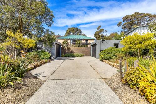 a driveway leading to a house with a blue umbrella at Secluded Luxury on Tower Hill in Somers