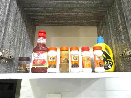 a shelf in a refrigerator filled with different types of condiments at Xellent Suites- Marg House in Nakuru