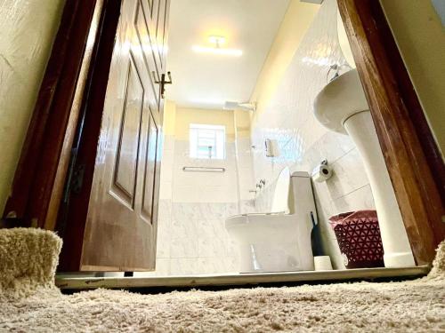 a bathroom with a sink and a toilet in a room at Xellent Suites- Marg House in Nakuru