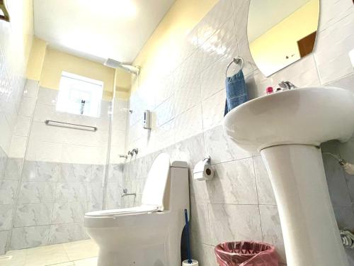 a bathroom with a sink and a toilet and a mirror at Xellent Suites- Marg House in Nakuru