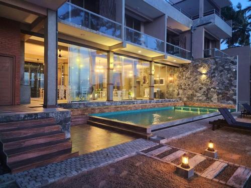 uma casa com uma piscina em frente em Adique's Resorts em Marawila