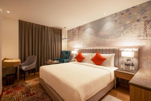 ボーパールにあるGolden Tulip Bhopalの大きなベッドとデスクが備わるホテルルームです。