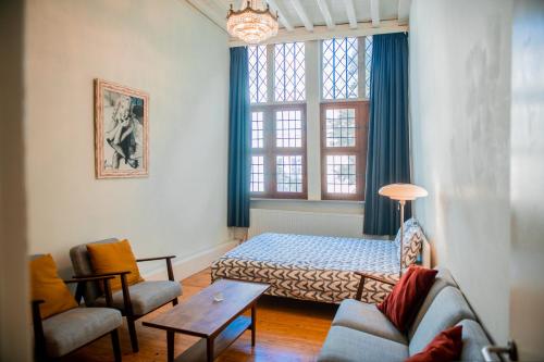 een kamer met een bed, een bank en een tafel bij Unieke woning in het historisch stadscentrum in Antwerpen