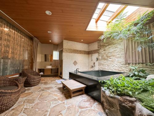 um quarto amplo com uma banheira numa casa em Yage Hotspring House em Jiaoxi