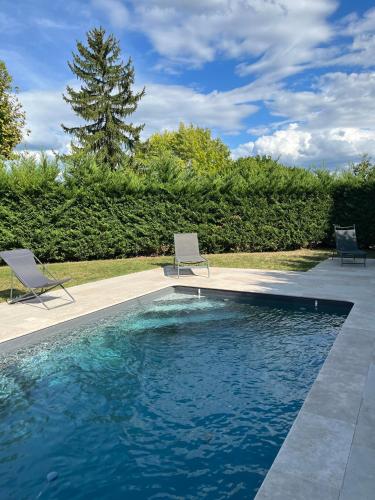 - deux chaises et une piscine dans la cour dans l'établissement Gîte Lomegaja 10 personnes proche Lascaux et Sarlat, à La Chapelle-Aubareil