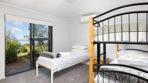 a bedroom with two bunk beds and a window at One Mile Retreat in Anna Bay
