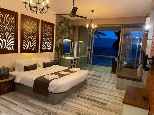 a bedroom with a bed and a view of the ocean at Adique's Resorts in Marawila