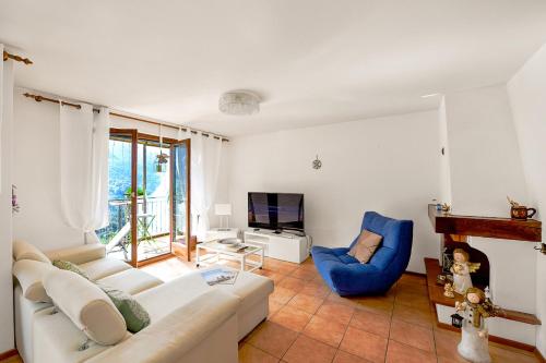 a living room with a white couch and a blue chair at Villa Delle Rose - Happy Rentals in Arogno
