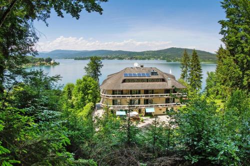 an image of a house on a lake at Holiday flats Seehaus Gaby Maria Wörth am Wörthersee - OKT01013-SYA in Reifnitz
