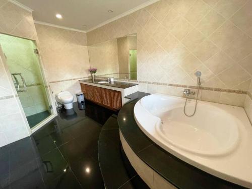 a bathroom with a tub and a sink and a toilet at View Talay Villas - Huge Luxury Pool Villa - 500m from Jomtien beach - 188 - old in Jomtien Beach