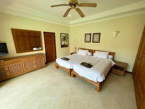 a bedroom with a large bed and a ceiling fan at View Talay Villas - Huge Luxury Pool Villa - 500m from Jomtien beach - 188 - old in Jomtien Beach