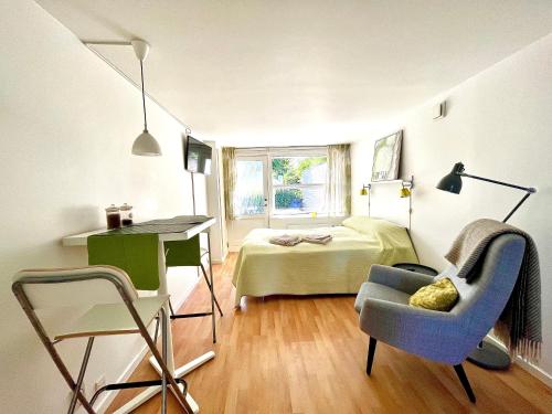 Vallensbæk的住宿－Cosy apartment with private terrace，一间卧室配有一张床、一张桌子和一把椅子
