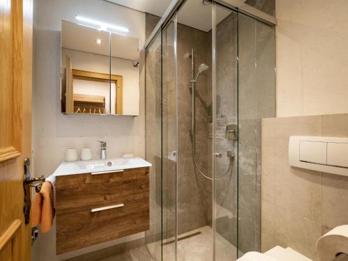 a bathroom with a sink and a glass shower at Appartement Bergblick in Brixen im Thale