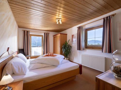 a bedroom with a bed with white sheets and a window at Appartement Bergblick in Brixen im Thale