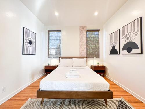 a white bedroom with a bed and two windows at Stylish Residence in Los Angeles - OL-WH in Los Angeles