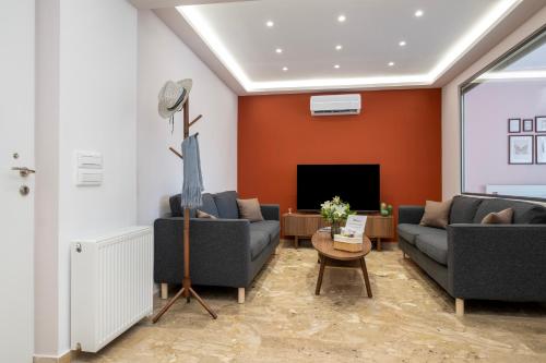 a living room with two couches and a tv at Urban Elegance - City Center 3-Bedroom Apartment in Chania