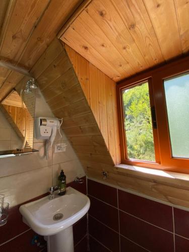 La salle de bains est pourvue d'un lavabo et d'une fenêtre. dans l'établissement Guesthouse Bec Villi, à Theth