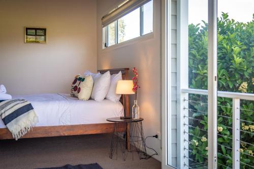 a bedroom with a bed and a window at Kulang Retreat in charming Broke with Large Swim Spa and games room suits up to 14 guests in Broke