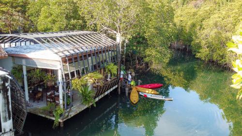 a building on the water with two kayaks on it at Escape Life Koh Kood in Ko Kood
