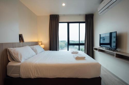 a bedroom with a large bed and a television at TheView Chaengwattana14 เดอะวิวแจ้งวัฒนะ14 in Bangkok
