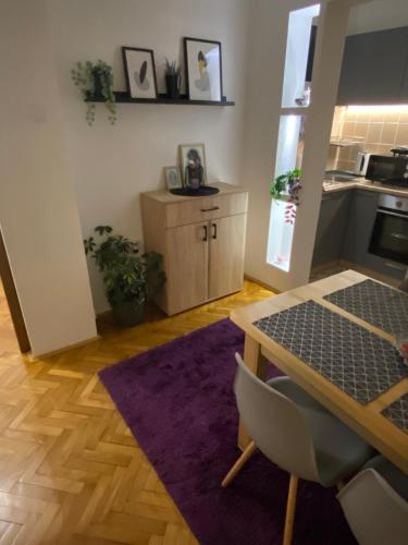ein Wohnzimmer mit einem Tisch und einer Küche in der Unterkunft Martina Lux in Belgrad