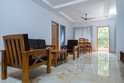 a living room with chairs and a table at Rashra Residency in Manipala