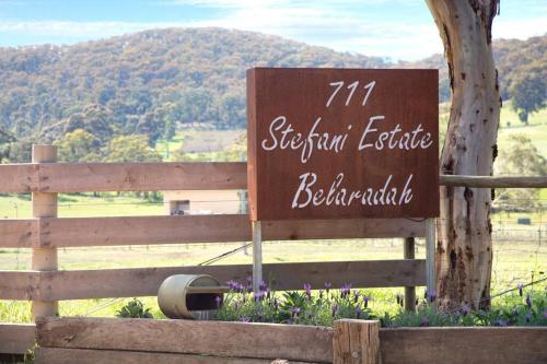 a sign on a fence with a mountain in the background at Belaradah on Stefani Estate Winery in Healesville
