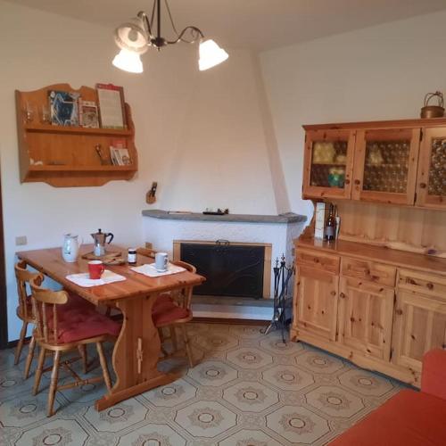 a kitchen with a wooden table and a fireplace at Rilassati al Corno alle Scale in Vidiciatico