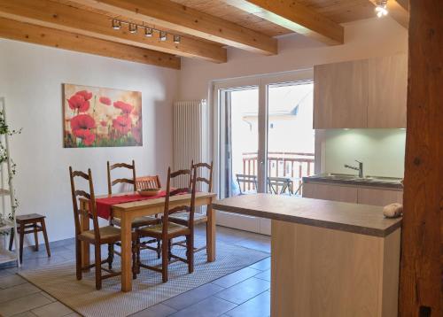 a kitchen and dining room with a table and chairs at À l'étape rêvée, charme, calme et nature in Baulmes