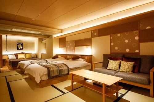 Habitación de hotel con cama y sofá en Sun Urashima Yuki no Sato en Toba