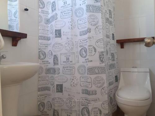 a bathroom with a toilet and a shower curtain at Room in Lodge - Valparaluz House, 2 People, Private Bathroom no1641 in Valparaíso